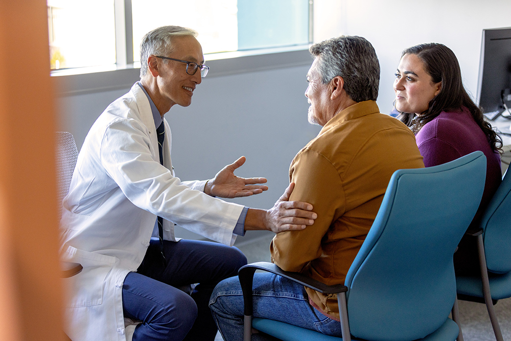 Doctor showing heart model to couple